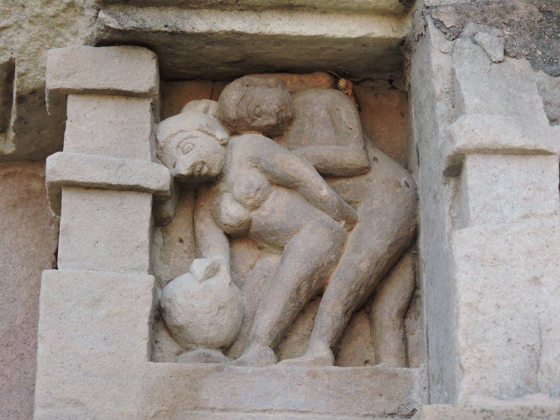 Statue of a man making love to a woman from behind while the woman take support on a rock