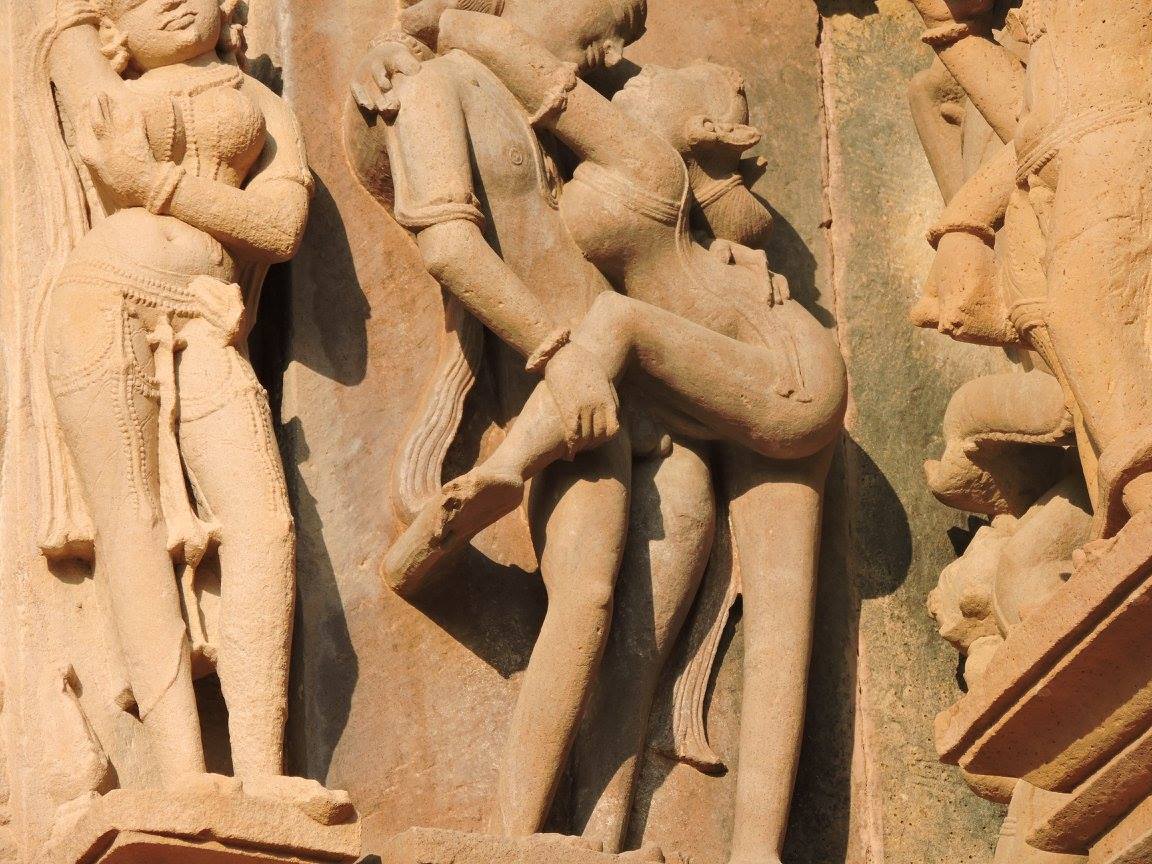 Statue of a woman hugging a man like vines around a tree in Khajuraho